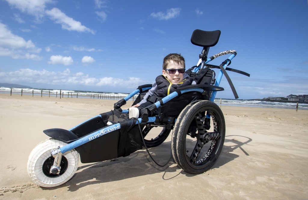 Saul Wilton 12, from Portrush enjoying Portstewart Strand thanks to a mobility chair bought by the Mae Murray Foundation through their Activate fundraising campaign